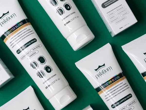 Bisnagas e caixas de dermocosméticos sobre fundo verde